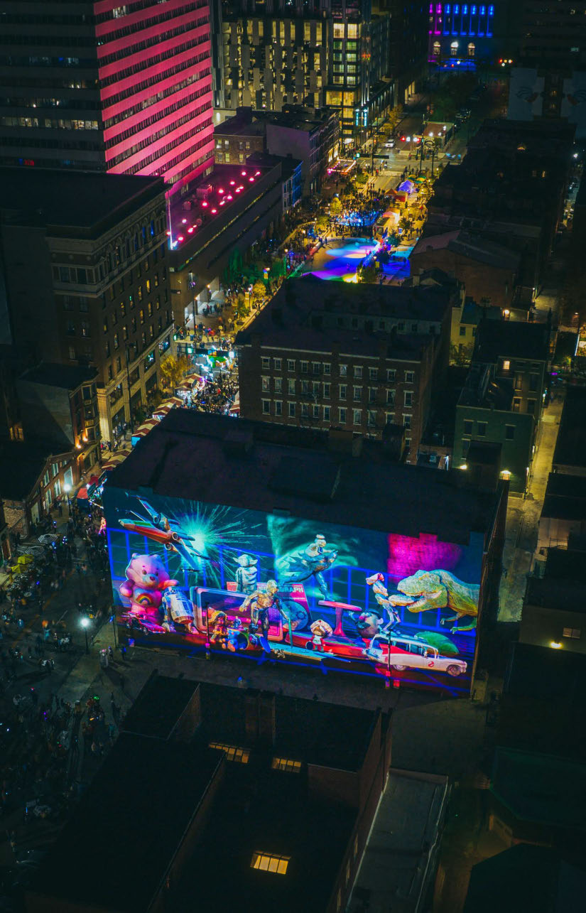 An aerial view of the Kenner toy mural illuminated during BLINK Cincinnati.